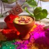 Luxury Holi thandai soy wax candle surrounded by vibrant gulal colors