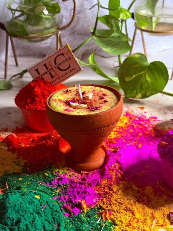 Luxury Holi thandai soy wax candle surrounded by vibrant gulal colors