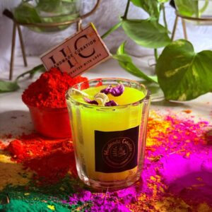 Thandai scented glass candle for Holi corporate gifting with saffron rose fragrance and festive gulal background