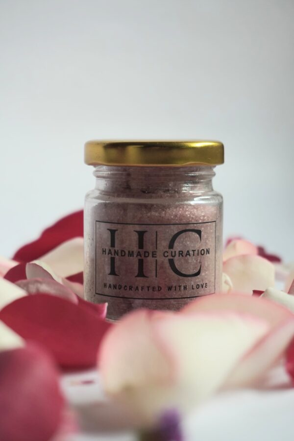 100gm handmade bath salt in glass jar with gold lid surrounded by rose petals