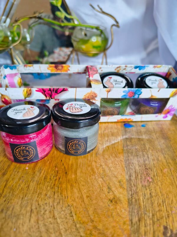 Set of colorful 25gm mini jar candles in red, white, green, blue, and purple displayed on a wooden base, perfect for home decor and gifting